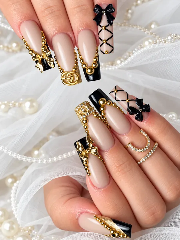 Long coffin nails in nude and black with gold chains and bows